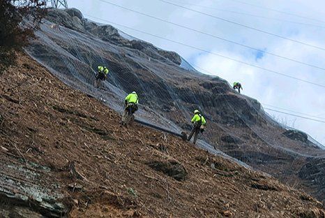 men installing a rock drape