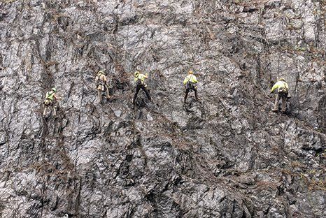 constructors climbing up cliff