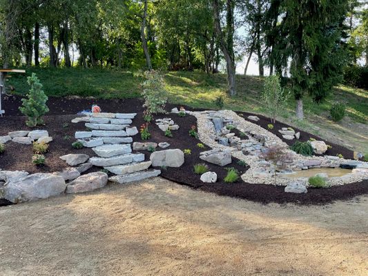 Image of a backyard with a waterfall and rock details