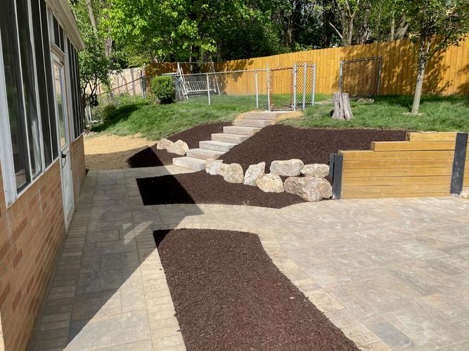 Image of a backyard with boulderscaping and hardscaping