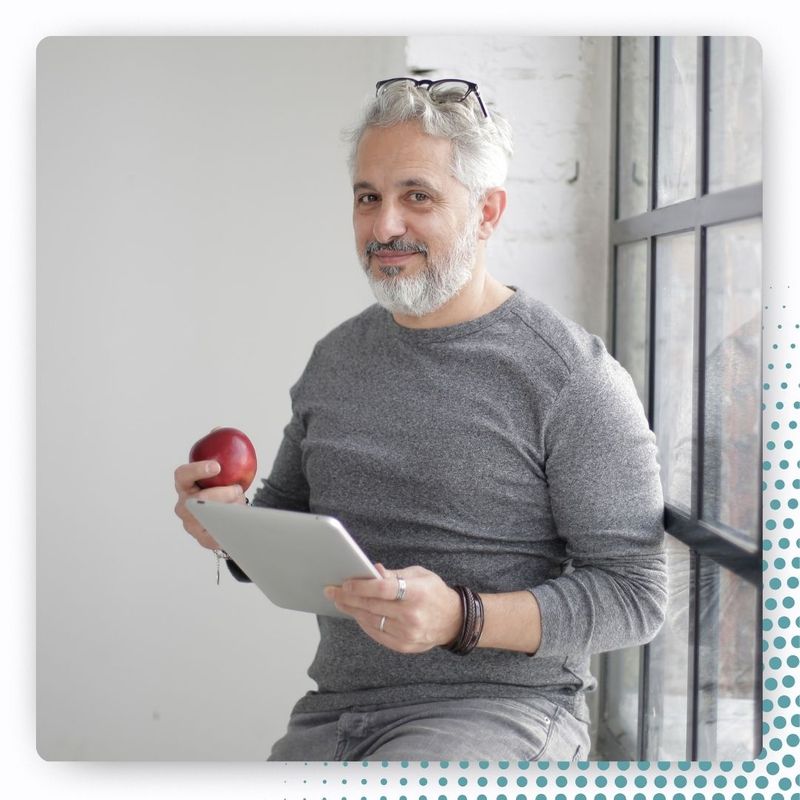 happy healthy aging man with apple and tablet
