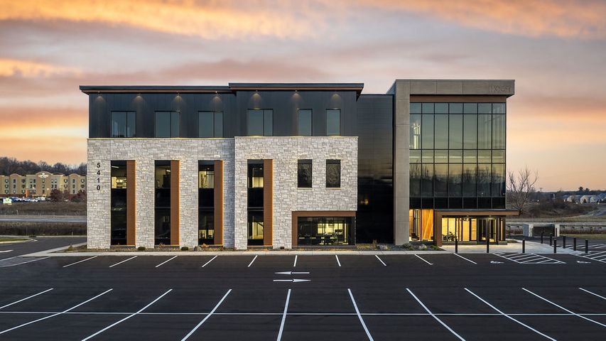 Image of corporate office exterior featuring stone siding, ACM panels, and a glass tower at Hoeft Builders in Eau Claire, WI Office exterior construction for Hoeft Builders in Eau Claire, WI