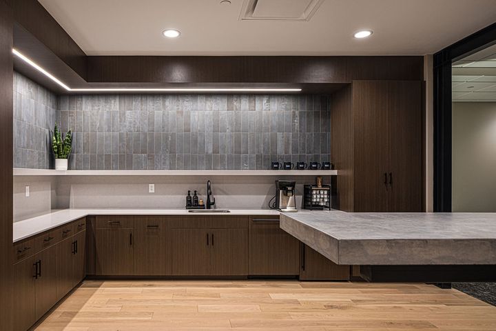 Office breakroom design and construction at Hoeft Builders in Eau Claire, WI featuring poured-in-place concrete bar top, built in cabinets, and a floating shelf. Breakroom construction at Hoeft Builders in Eau Claire, WI