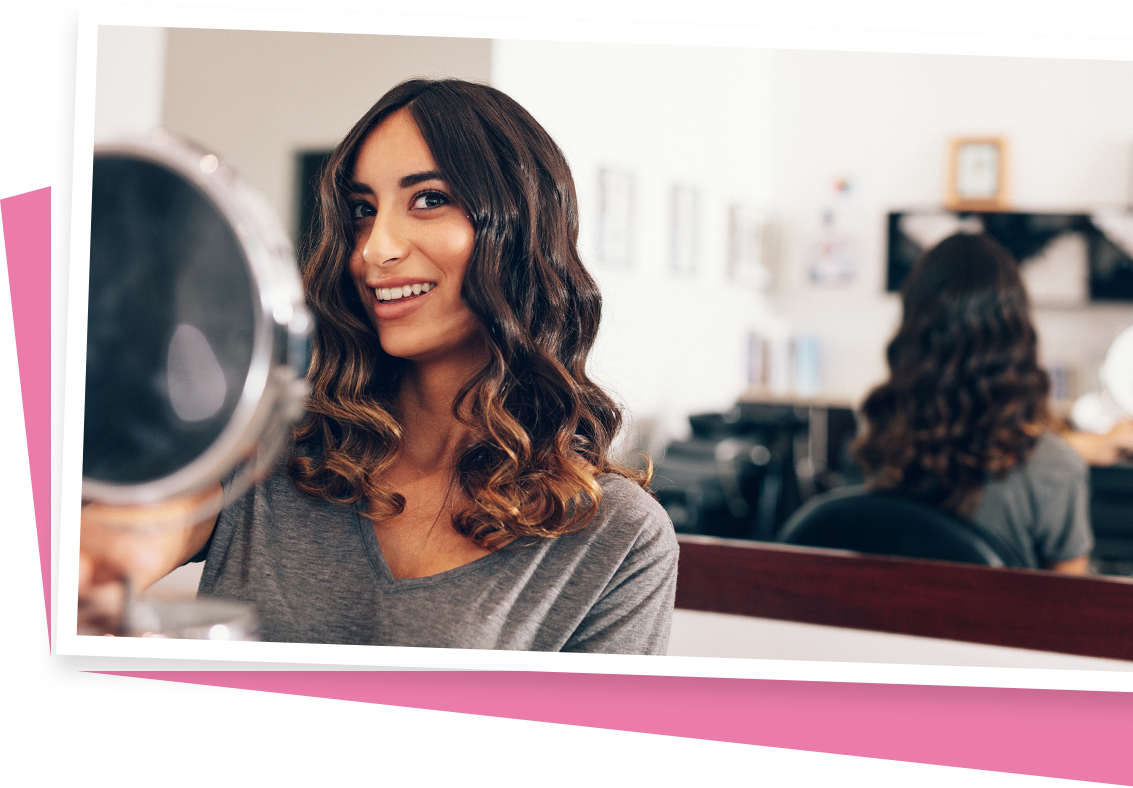 woman looking at hair cut in the mirror