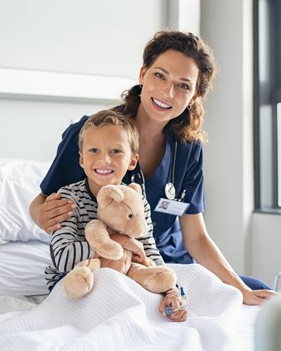 A nurse sitting with a smiling boy